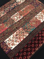 Patterned fabric strips arranged in a patchwork design on a dark background